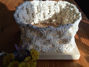 Pappersgarn stickat i honungskakemönster med björkbottenplatta